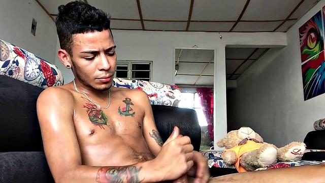 tattooed latino tugging his shaved cock
