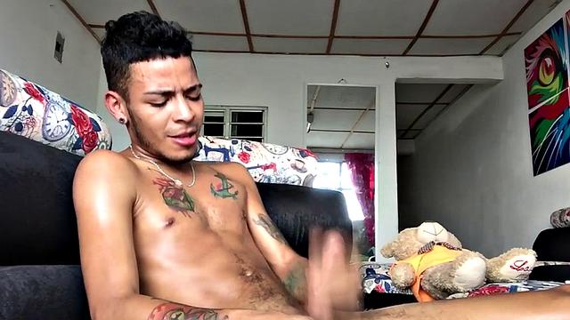 tattooed latino tugging his shaved cock