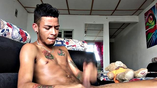 tattooed latino tugging his shaved cock