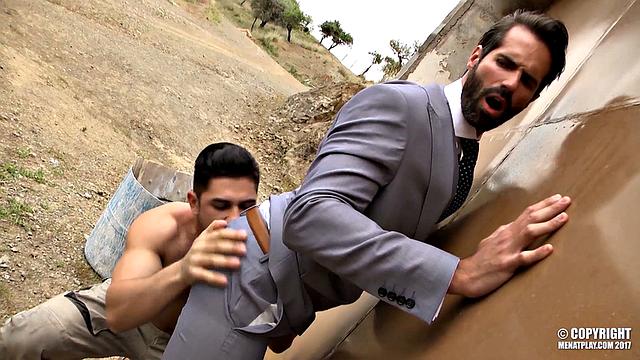 two suited guys use a work blueprint as an excuse to fuck in the office