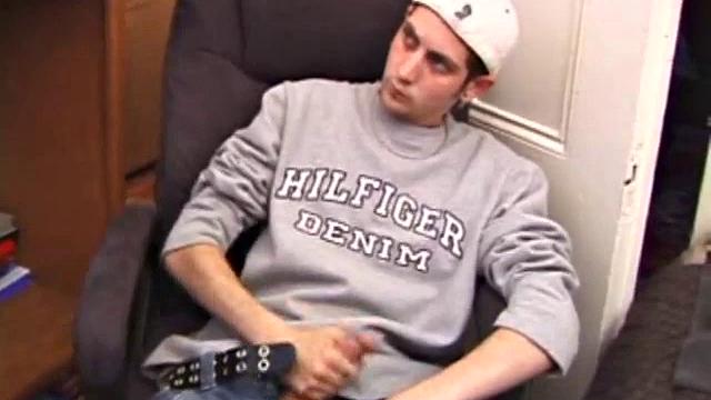 As a porn flick plays, young amateur Aaron Michaels strokes hard, pulls his cock out of his jeans, lets loose, and spills his nut on the bed.