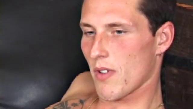 These two tough looking skater boys are on the floor, leaned up against some black leather pillows, with their cocks.