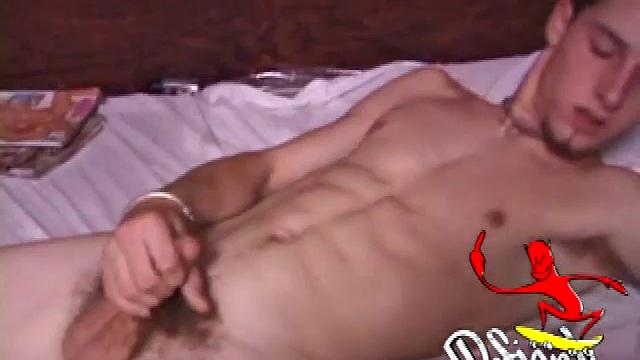 Adam thumbs through a porn magazine, hardens up, uses dildo, shows ambidextrous talents, strokes.