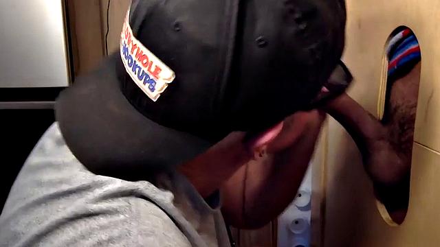 Gloryhole inked DILF sucks BFs cock through hole at home