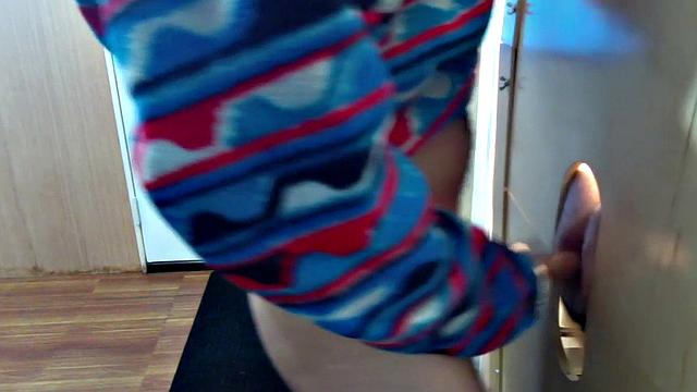 Gloryhole inked DILF sucks BFs cock through hole at home