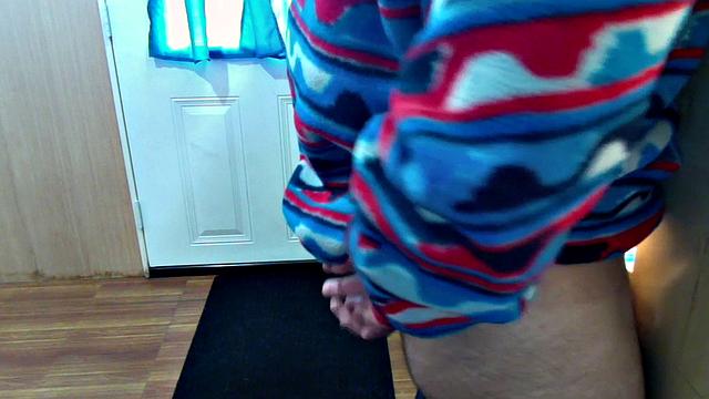 Gloryhole inked DILF sucks BFs cock through hole at home