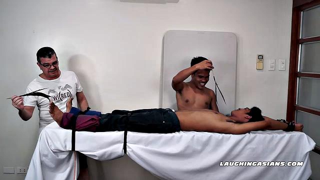 This cute tight-bodied ticklish Asian is Kenny Cruz. Jacob takes joy in strapping him down for some tickle fetish action.