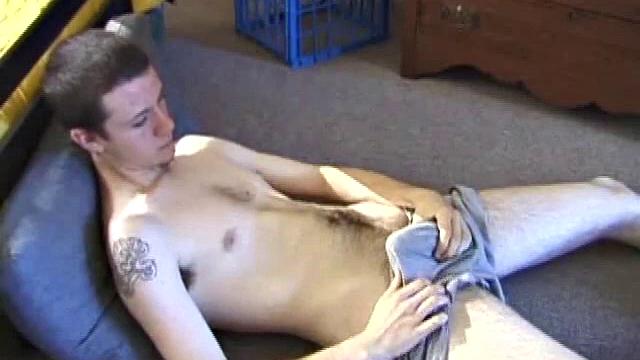 After using the remote to cue up a porn video, young Derek massages his crotch and wakes up his monster. Once the clothes are off, he starts to stroke and it doesn't take long for Derek to cum all over his hairy tummy.