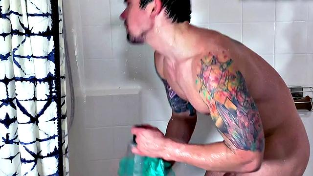 Muscled tattoo guy jerks and fucks sex toy in the shower