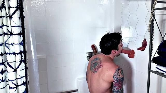 Muscled tattoo guy jerks and fucks sex toy in the shower