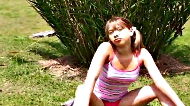 Petite teen strips off outdoors on grass