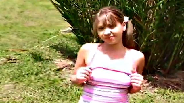 Petite teen strips off outdoors on grass