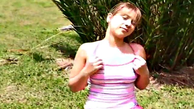 Petite teen strips off outdoors on grass