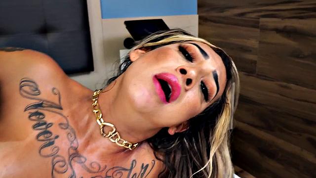 Sexy shemale with oiled-up pierced nipples takes on a massive black cock in her asshole