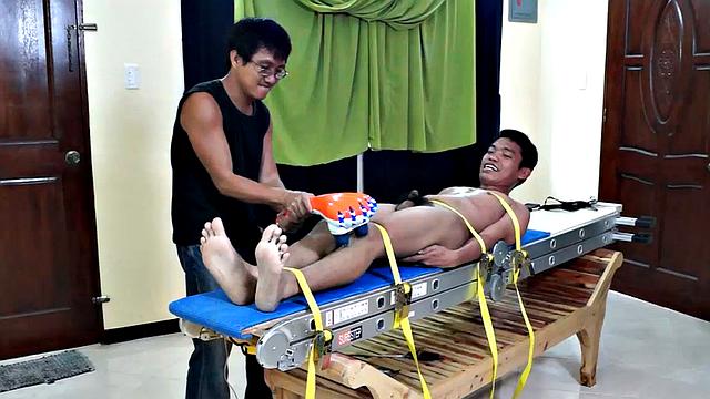 This Asian boy Lorenzo has some very ticklish feet. We strapped him down on the tickling rack and worked those smooth male soles. Ricky made sure to tickle the armpits while Daddy Mike feathered his soles.