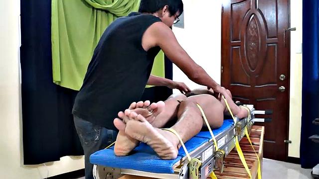 This Asian boy Lorenzo has some very ticklish feet. We strapped him down on the tickling rack and worked those smooth male soles. Ricky made sure to tickle the armpits while Daddy Mike feathered his soles.