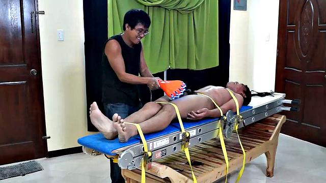 This Asian boy Lorenzo has some very ticklish feet. We strapped him down on the tickling rack and worked those smooth male soles. Ricky made sure to tickle the armpits while Daddy Mike feathered his soles.