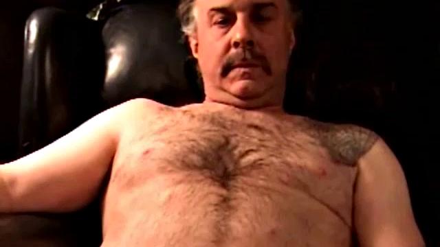 Robert is a dump truck driver and has that big hairy bear look. He's a simple and very pleasant guy to be around. He likes getting his dick sucked and will sometimes return the favor. In this solo, he gets naked, sits in a chair and jacks off.