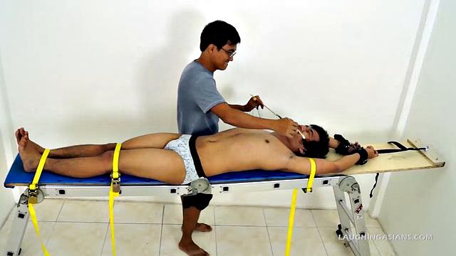 This adorable gay Asian boy is Ronny. He's 19 years old and insanely ticklish. This will be Ronny's introduction to the male tickling world as Ricky has him strapped down for some kinky fun.