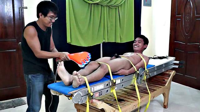 This giggly tickly Asian boy had some real ticklish feet. The feathers seemed to drive him crazy, so when we hit him, he went nuts!