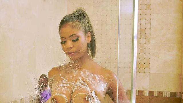 Watch this busty ebony babe get her bald pussy pounded by a white guy's big dick in the shower