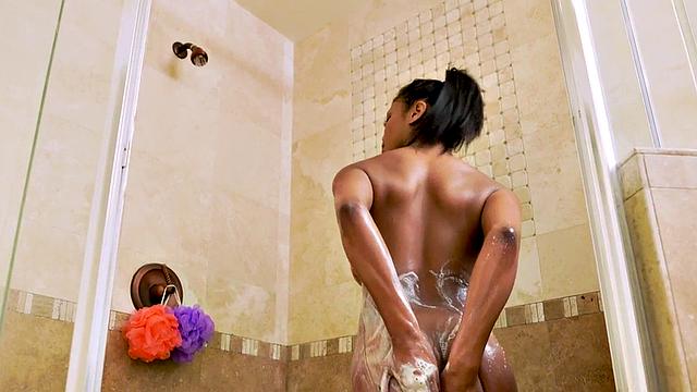 Watch this busty ebony babe get her bald pussy pounded by a white guy's big dick in the shower