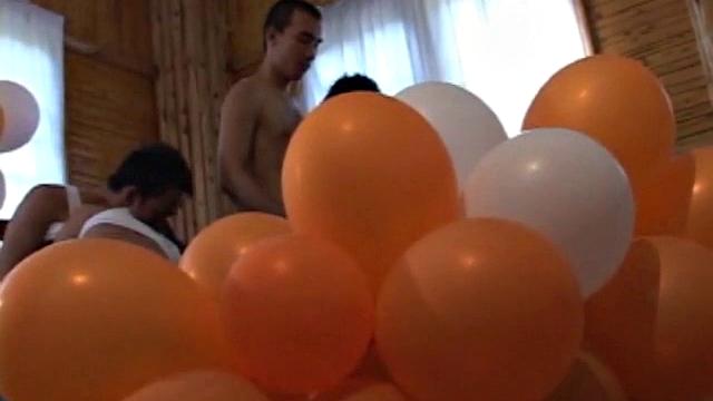 Eight boys play a game of strip balloons where a giant dice determines who undresses