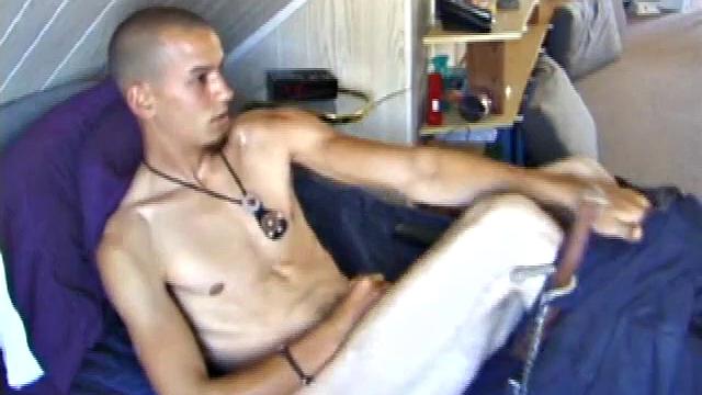 Young amateur Brandon reclines on the sofa and pulls off his pants. Watching porn video, he rubs his dick hard and fingers his asshole.