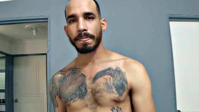 Leon stands in a door way and starts getting himself hard, as he strips. Naked and sporting a big boner, the horny Latino moves to a bed and starts jerking off.