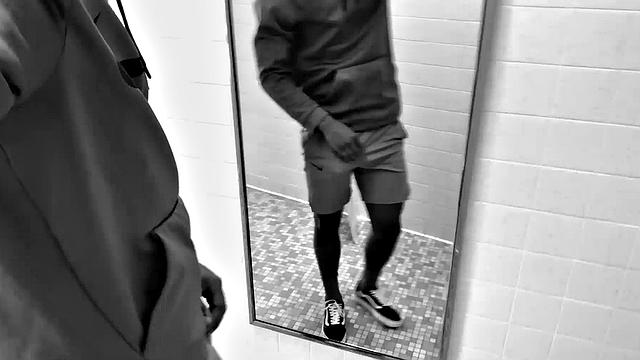 Filmed in black and white, Chris is in a public bathroom to show us his stuff. Already sporting a big boner, he drops to reveal a beautiful dick and fine ebony butt.