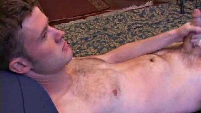 Nate Ritchie strokes his cock to full mast, his eyes glued to the porn video playing. He strokes lying down, standing up, before deciding the best way to unload is upside down.