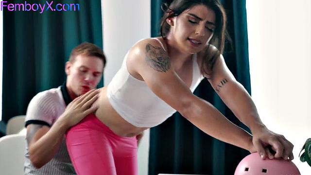 фембой с длинными волосами растягивает жопу на йоге с тренером