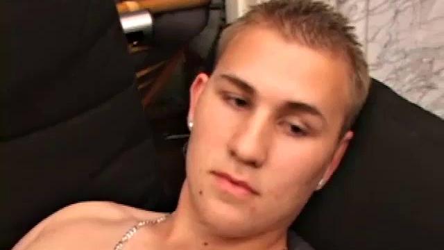 After stripping naked, Adrian Knutts works the remote control, as he strokes his cock to the porn flick that's playing. He sticks a finger up his ass to help him get closer, before shooting a big warm load onto his chest and face.