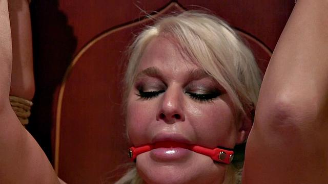 Lezdom toying submissive with dildo while rubbing