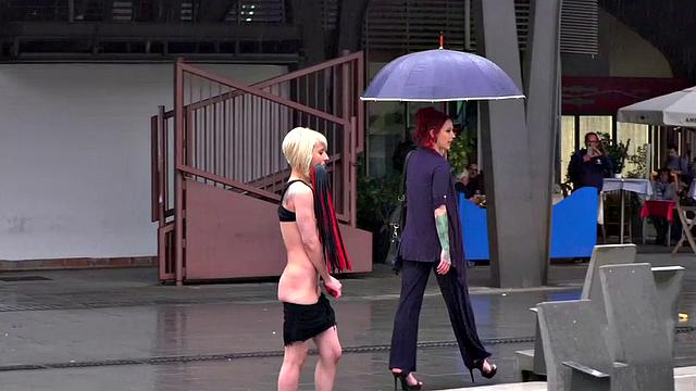 Lezdom redhead MILF shows teen servant outdoors in public