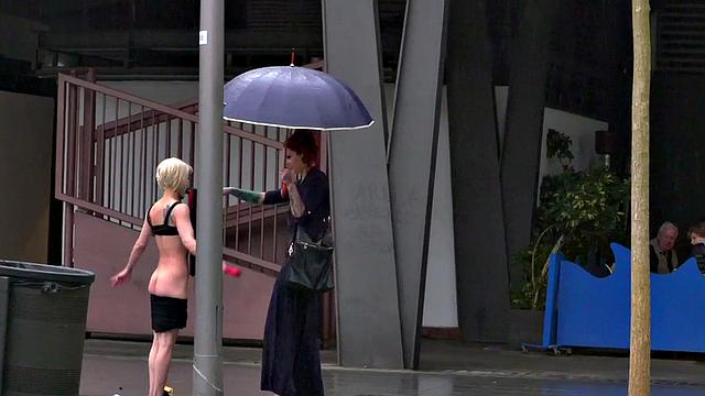 Lezdom redhead MILF shows teen servant outdoors in public