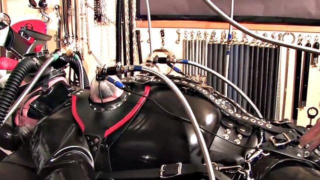 Femdom latex domina torments sub with cock pump