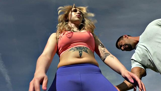 Tattooed blonde tgirl gets bred from behind in the gym