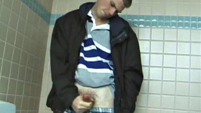 We catch up with Christian on an outdoor stairway. He leads us to a men's room with glory holes. Tere, Christian jacks off to photos in a straight porn magazine.