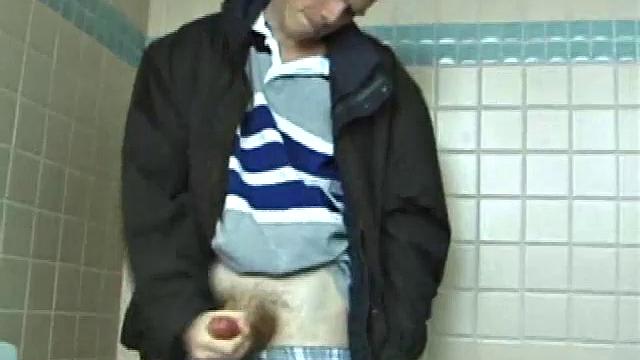 We catch up with Christian on an outdoor stairway. He leads us to a men's room with glory holes. Tere, Christian jacks off to photos in a straight porn magazine.