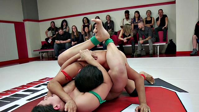 Public naked wrestlers fight on mat in front of audience