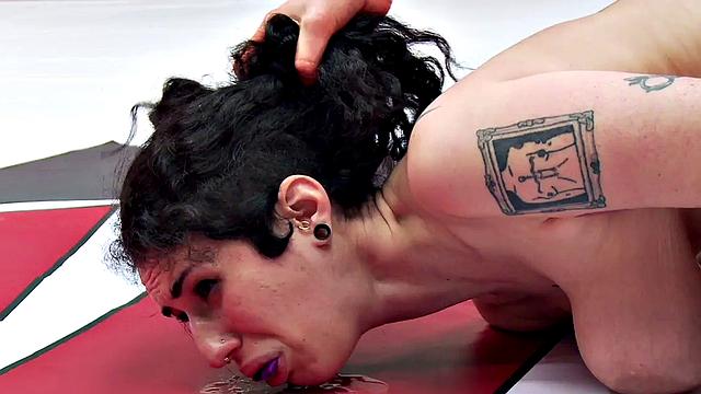 Athletic brunette wrestler loses to big-titted babe with strapon in a wrestling match