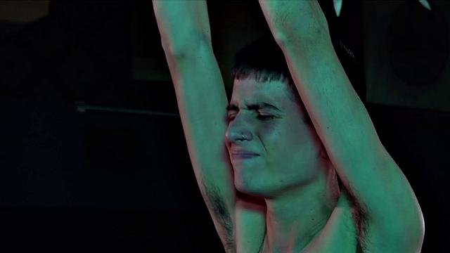 Bound and hanging from a rope, shirtless Andreas is in the hands of Calvin. He pushes the boy's pants down to expose his butt and gives Andreas a good paddling. Then Calvin spreads those rosy cheeks to expose a cock hungry hole.