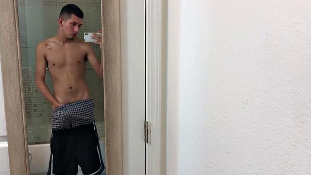 Slim and smooth Roman is in the bathroom, wearing only a pair of shorts. The young Latino gropes at his package until he's boned up. Then the shorts are pushed down to reveal his big uncut dick.
