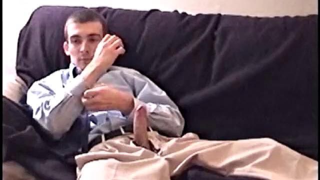 Darrell kicks back on the sofa, makes himself comfortable, rubs his package to work up a bulge, and then releases a big cock. At the same time, he pulls off his dress shirt and tie.