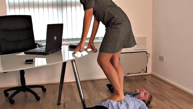 строгая блондинка топчет и шлёпает своего любителя ножек в офисе