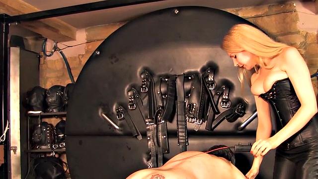 Leather BDSM domina whipping her sub in lesson
