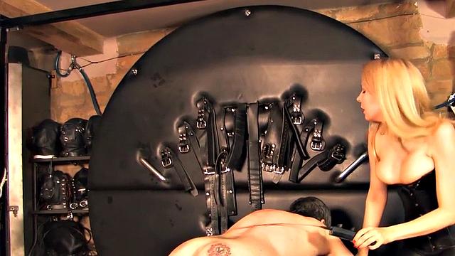 Leather BDSM domina whipping her sub in lesson