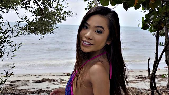 Kinky tattooed brunette gets wet and wild on the beach with a ball in her mouth and pussy