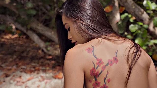 Kinky tattooed brunette gets wet and wild on the beach with a ball in her mouth and pussy